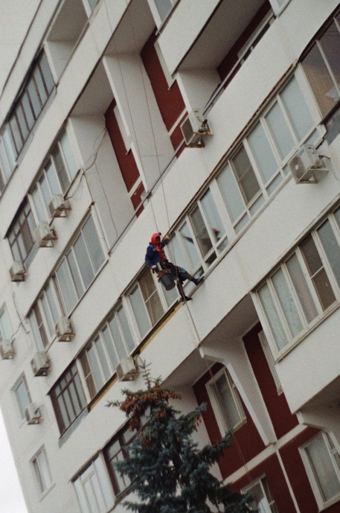 Window cleaner rappels down a building facade
