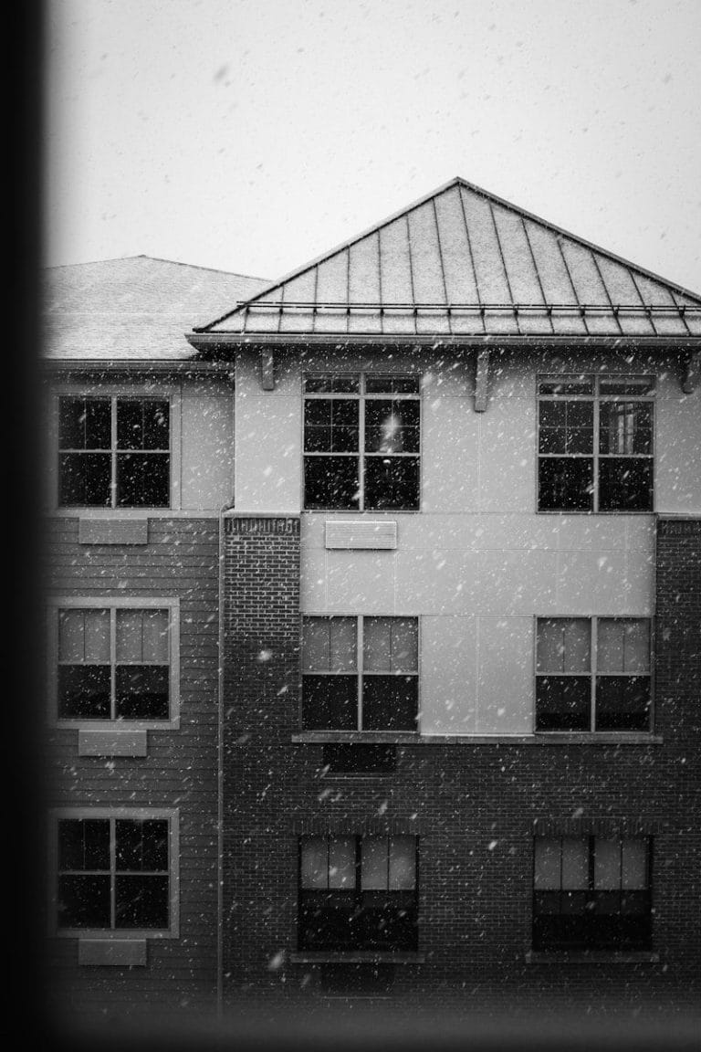 Snow falling on an apartment building exterior.